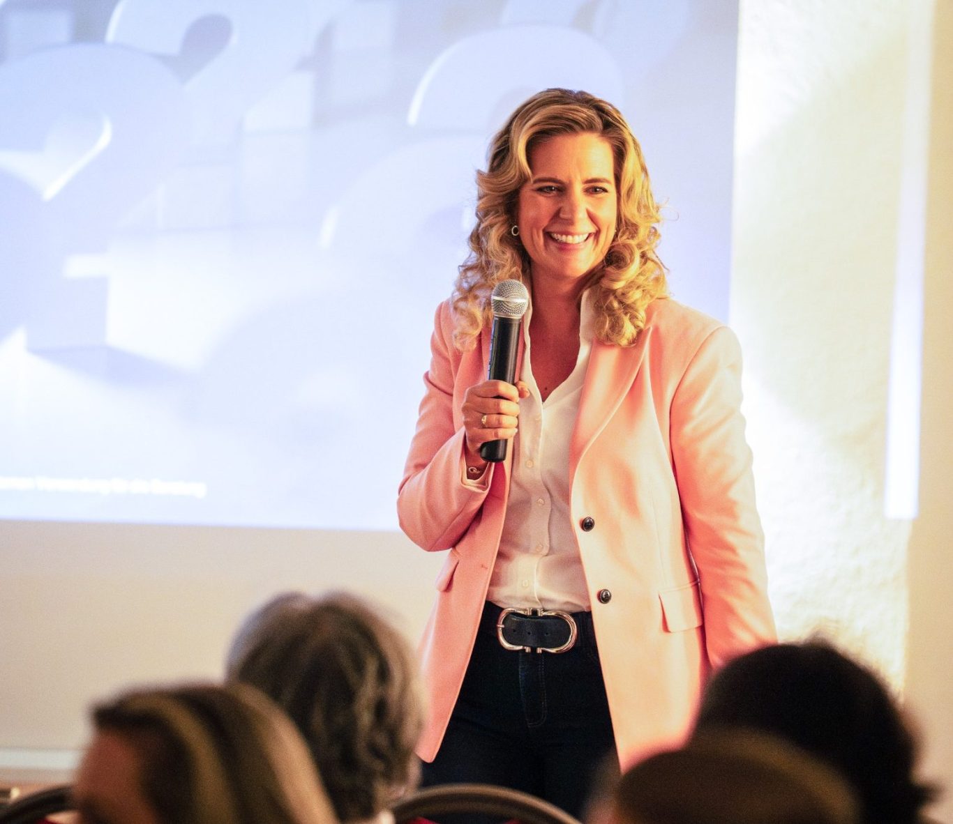 Natascha Enders – Keynote Female Finance Natascha Enders lächelt im schwarzen Blazer, lehnt an einer Betonwand – Teaser zur Keynote Female Finance